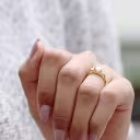 oval lab grown diamond set in a yellow gold oval three stone setting with a trellis