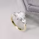lab grown oval diamond with pear cut lab grown diamond side stones set in a two tone setting of 14k yellow and white gold ada diamonds design ad-460