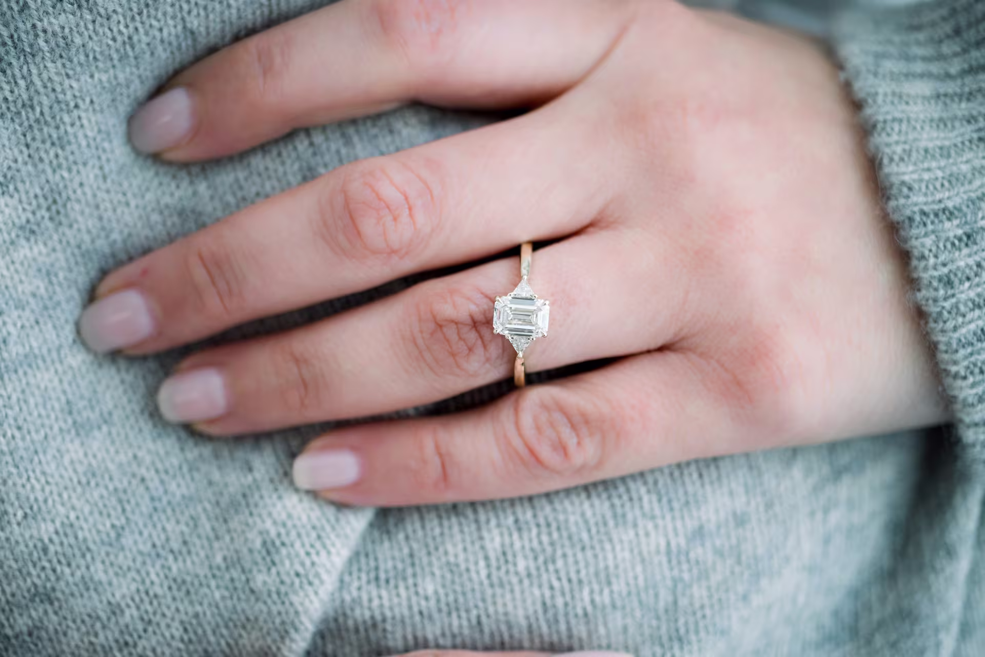 1.25ct emerald cut in three stone engagement ring