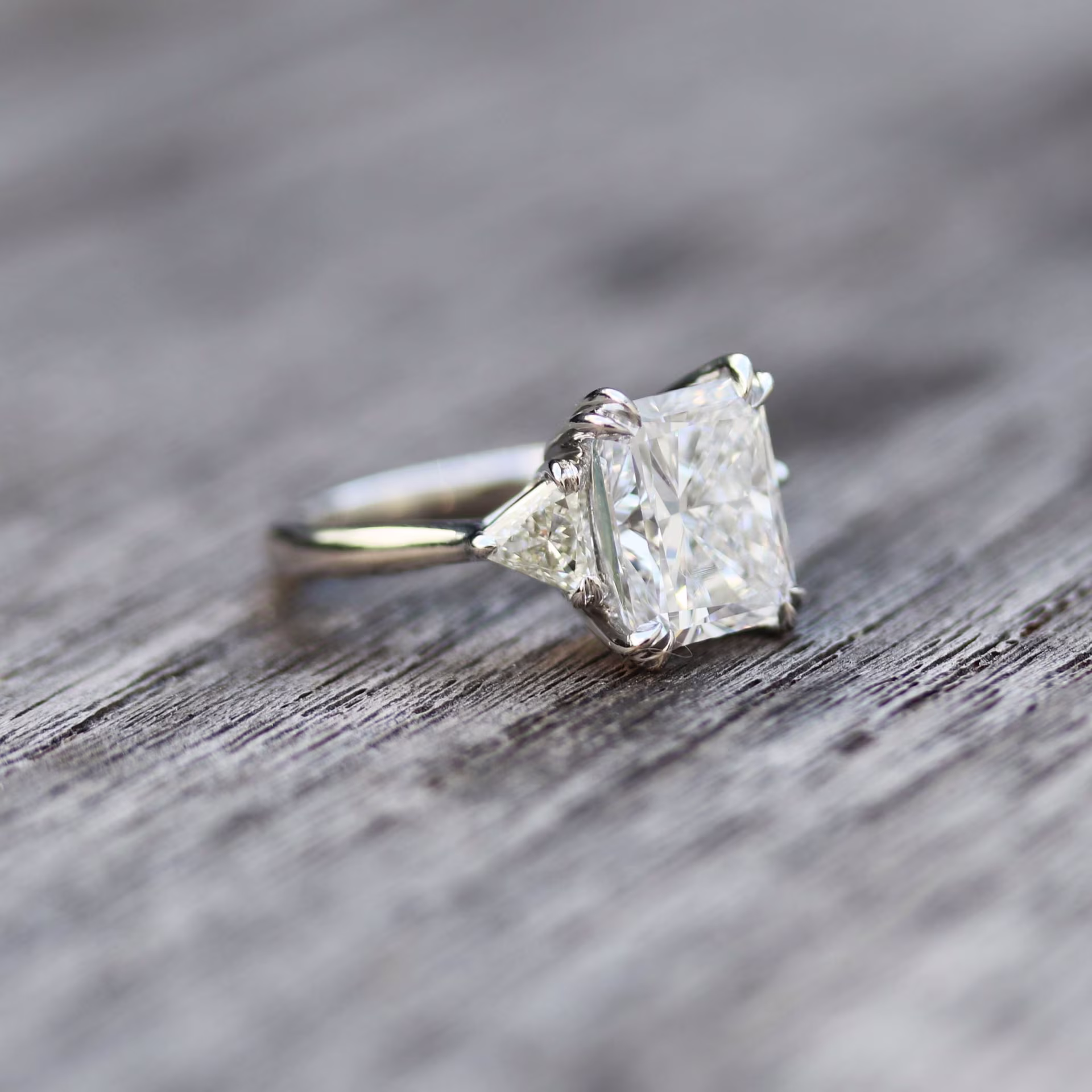 custom double claw prong lab grown diamond engagement ring featuring 2 carat lab grown radiant with trillion side stones