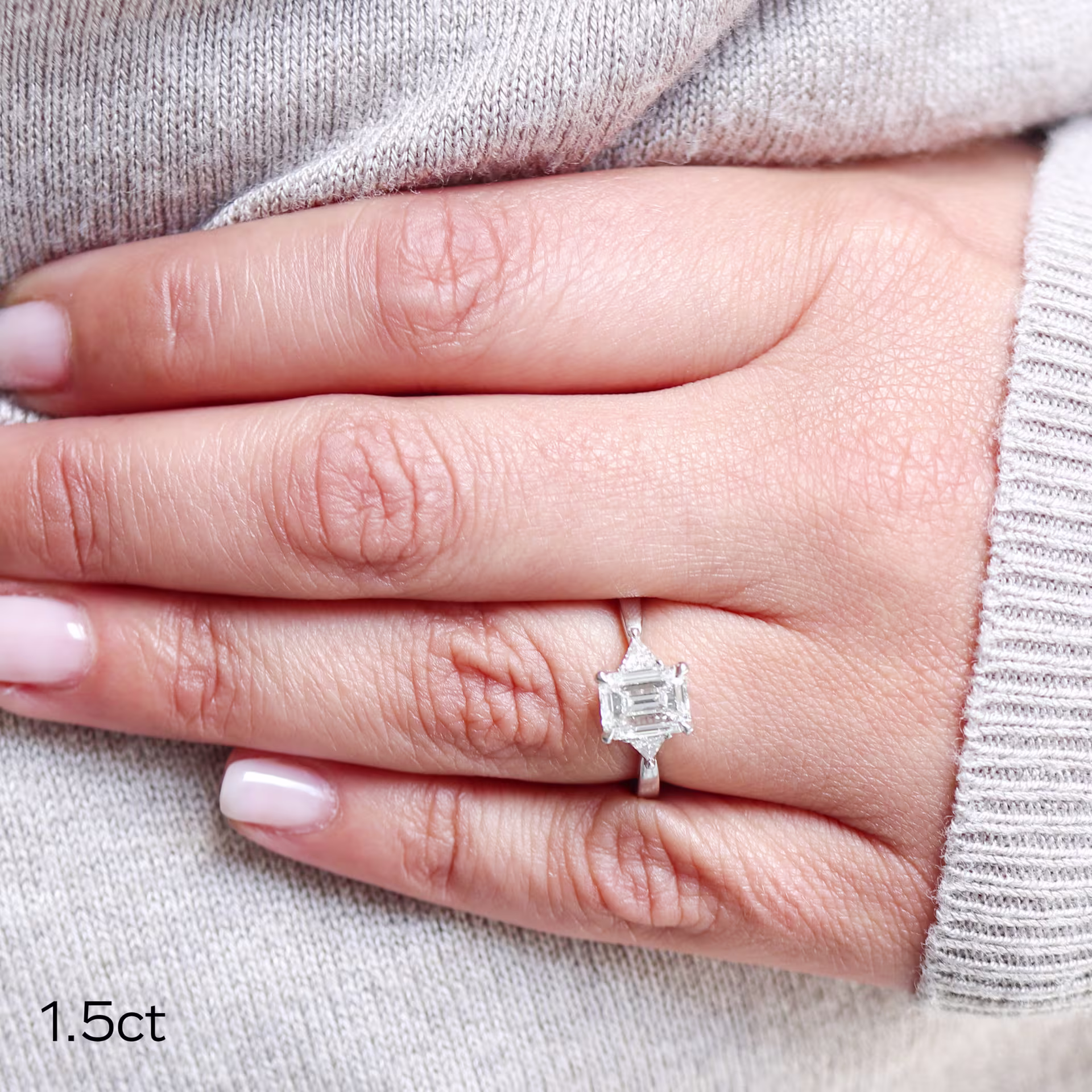 custom white gold emerald and trillion ring featuring a 1.5 ct emerald cut lab grown diamond and lab grown side stones