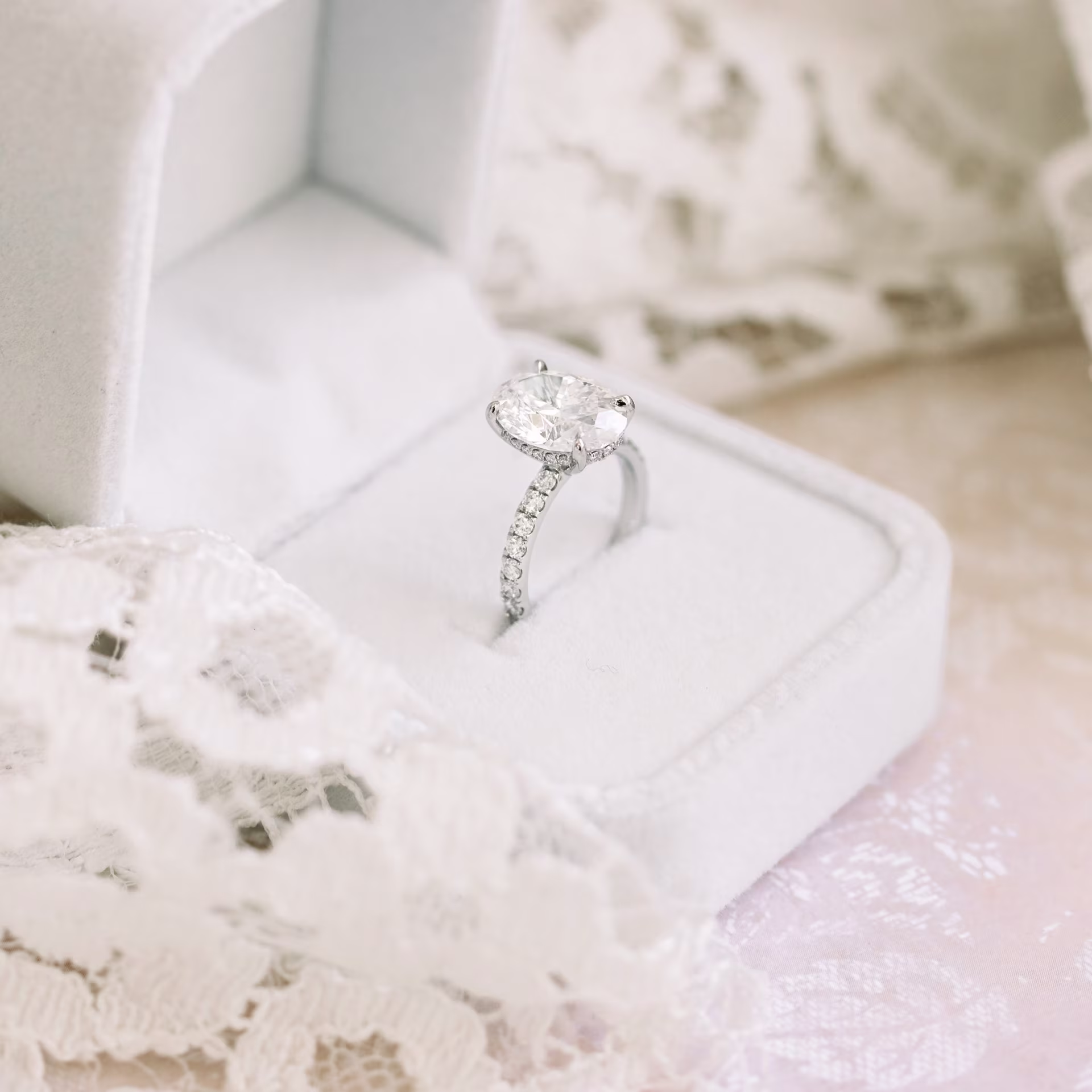 Platinum Oval Petite Four Prong Pavé Setting featuring Hand Selected Man Made Diamonds