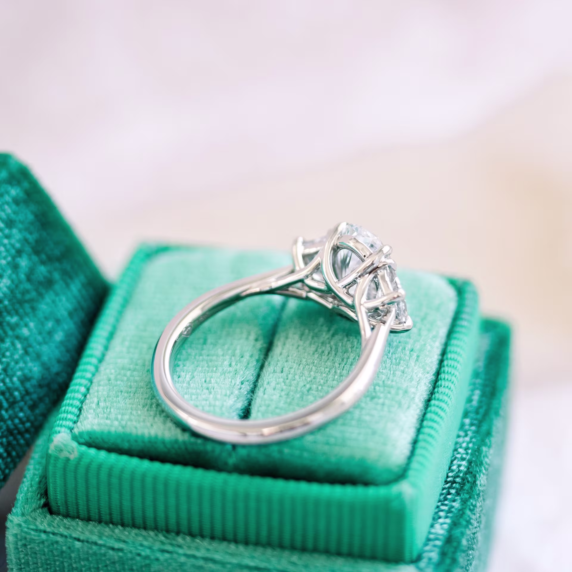 18k white gold 2.5 carat oval lab created diamond three stone ring with trapezoid side stones design ad 462 profile view