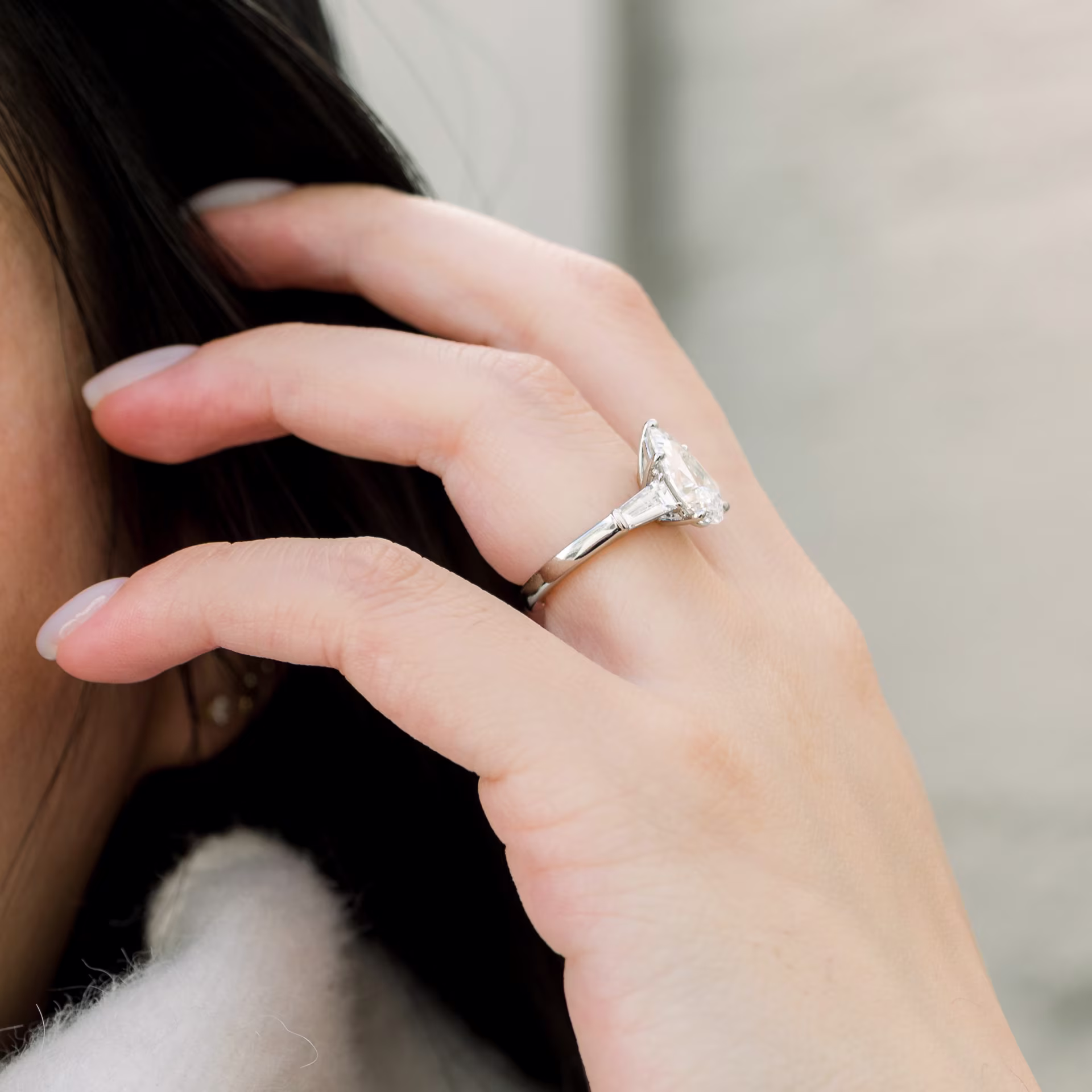 platinum three stone lab diamond engagement ring with 2.5ct pear center stone and baguette side stones profile view on model ada diamonds design ad 495