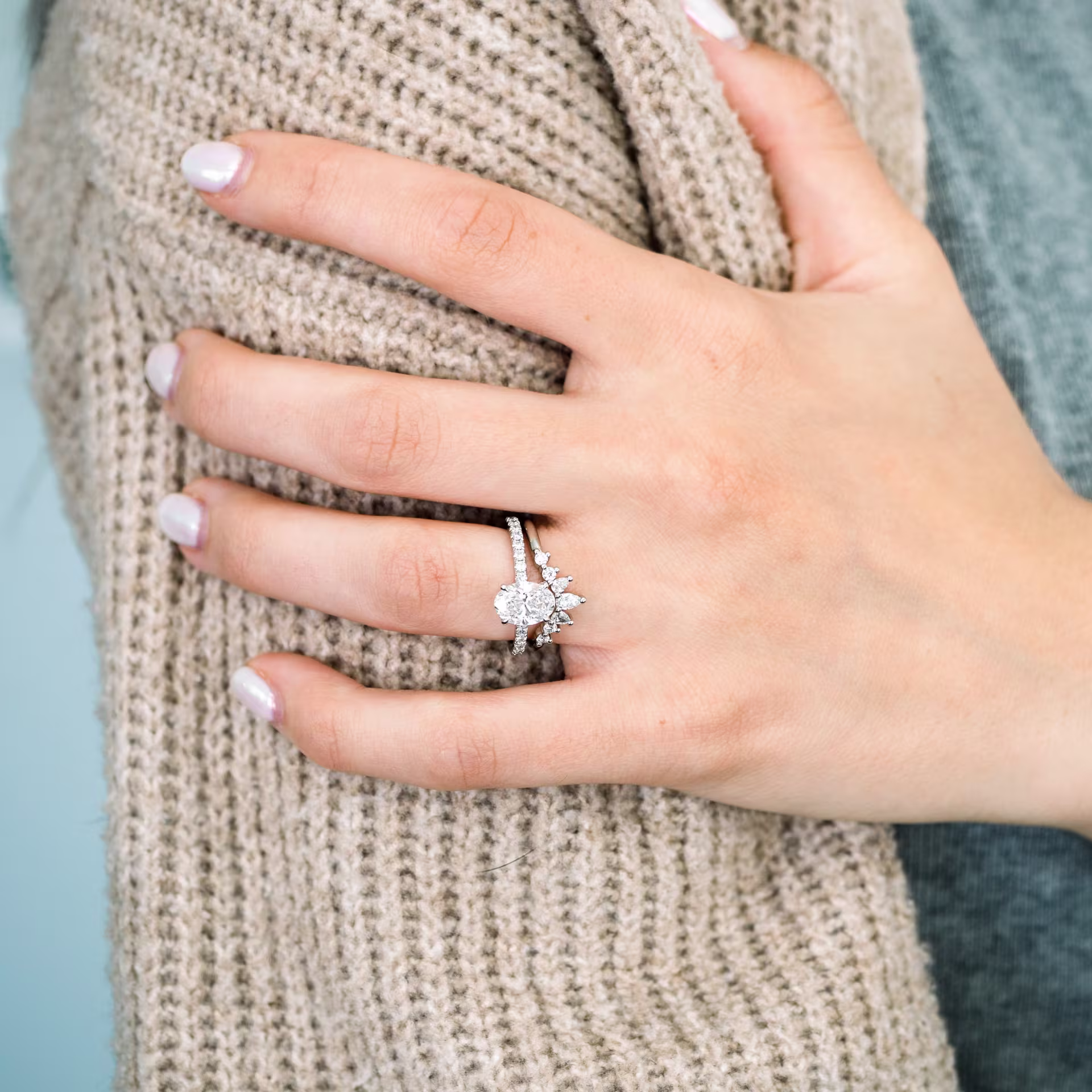 lab diamond wedding set featuring oval pavé engagement ring and round and pear nesting band in platinum on model ada diamonds design ad 182 and ad 230