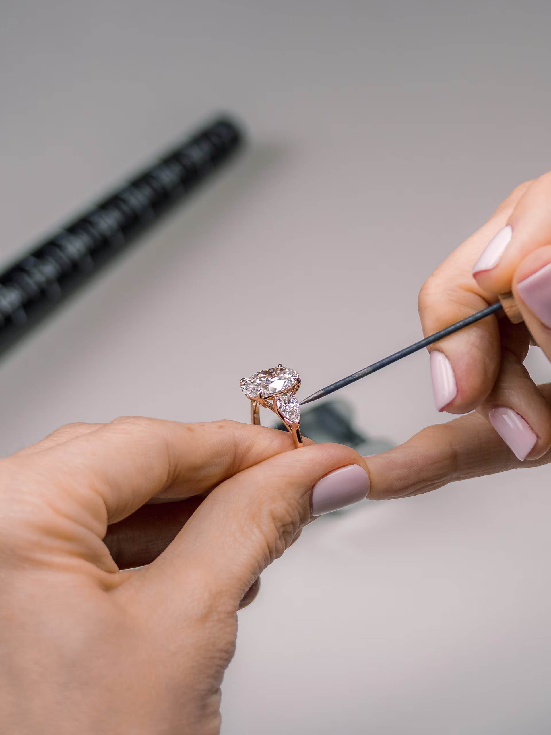 Jewelry examining a finished lab diamond engagement ring for quality control