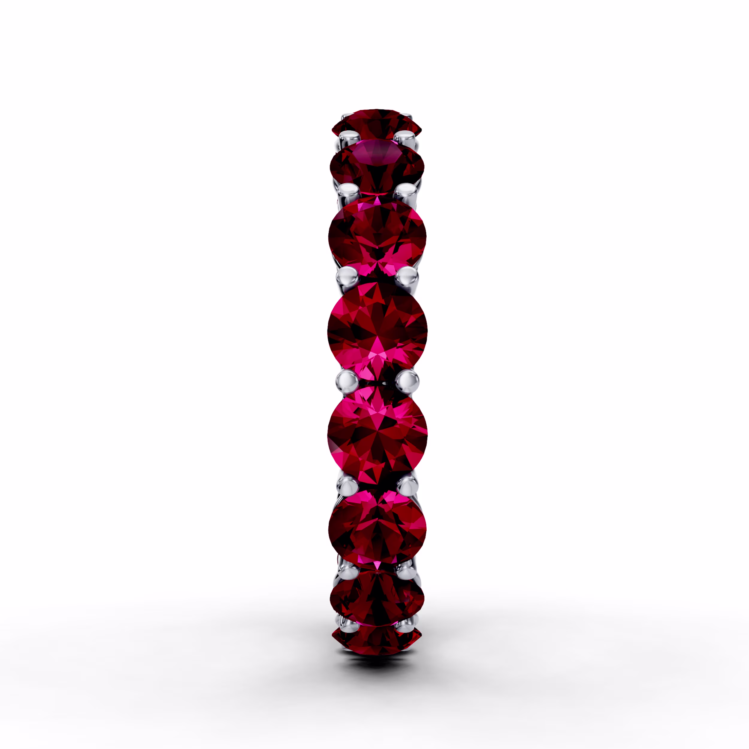 Platinum round ruby prong set eternity wedding band in white metal featuring melee stones.