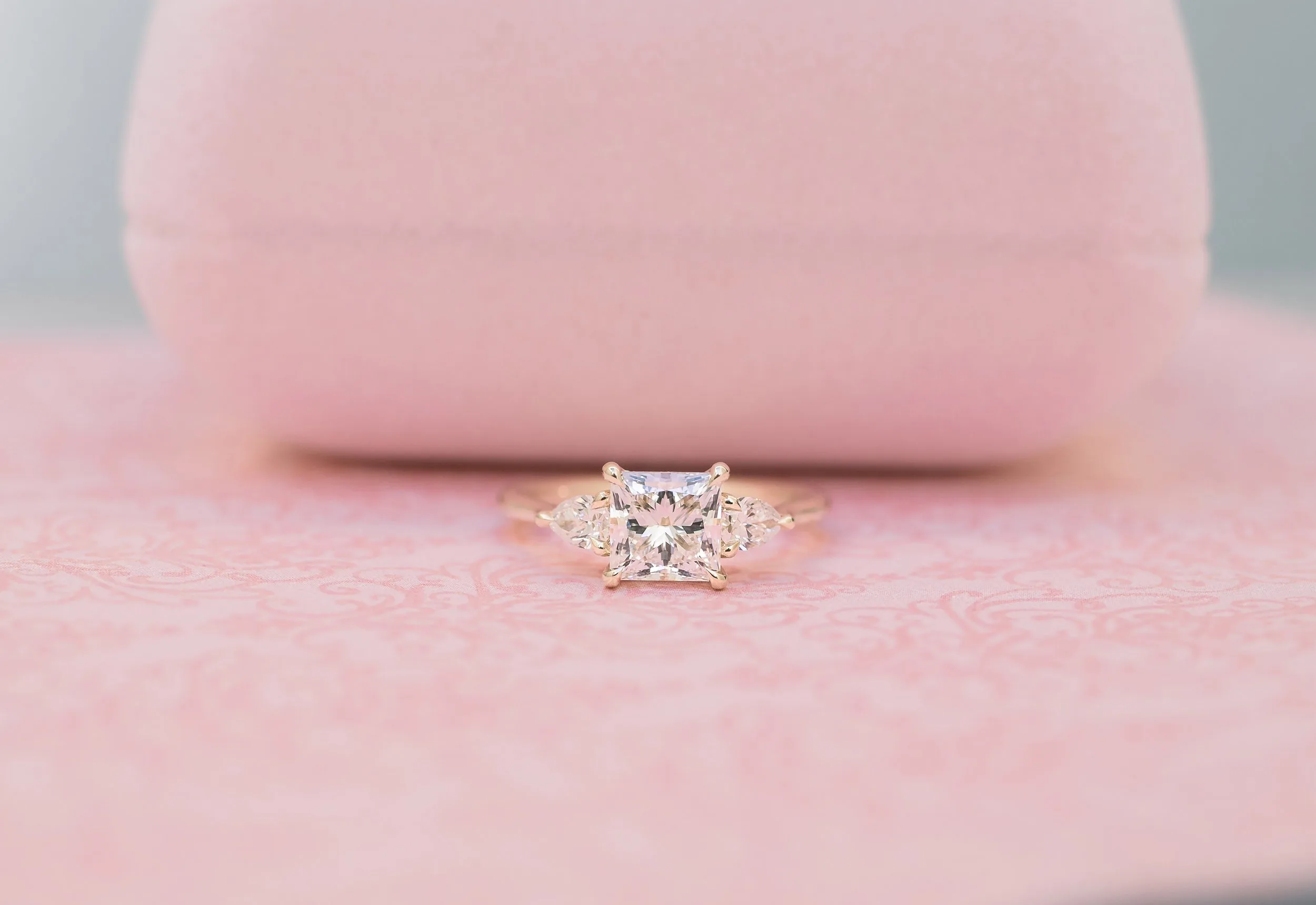 lab created three stone engagement ring with pear and princess cuts