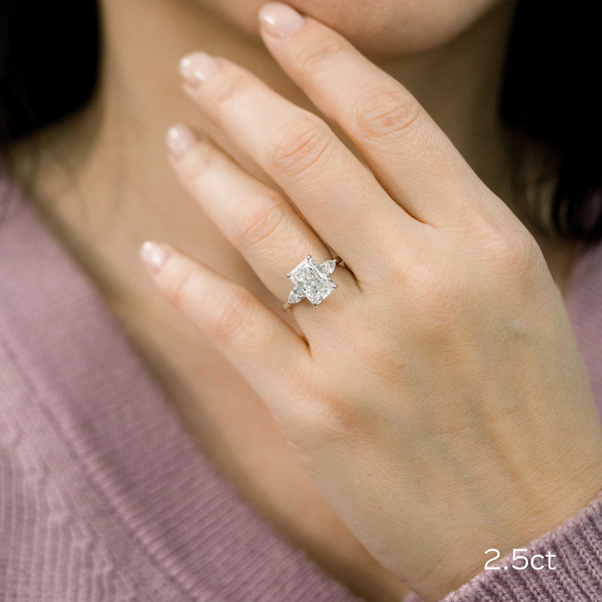 18k white gold 3 carat radiant cut and pear three stone lab diamond engagement ring on model