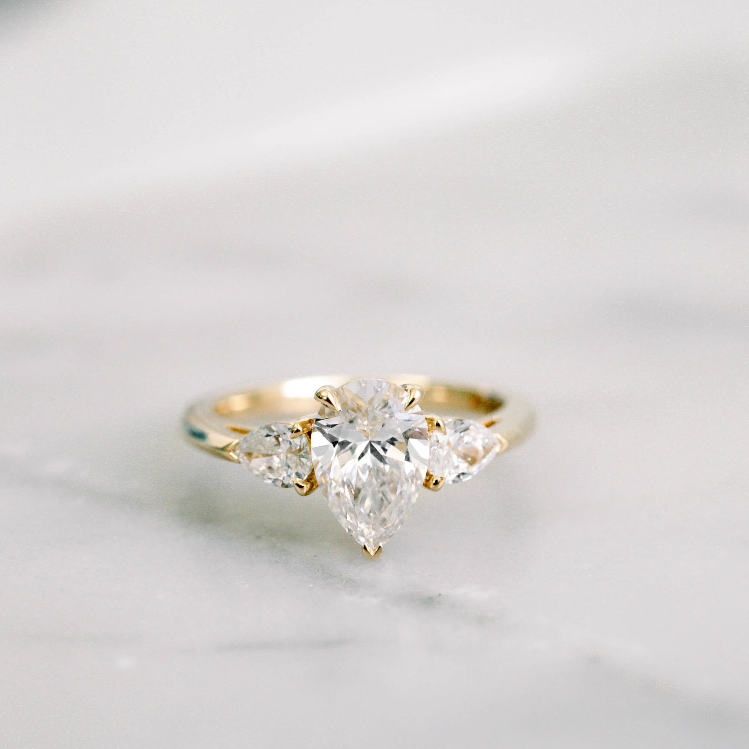 18k yellow gold three stone ring featuring pear shape lab grown diamonds