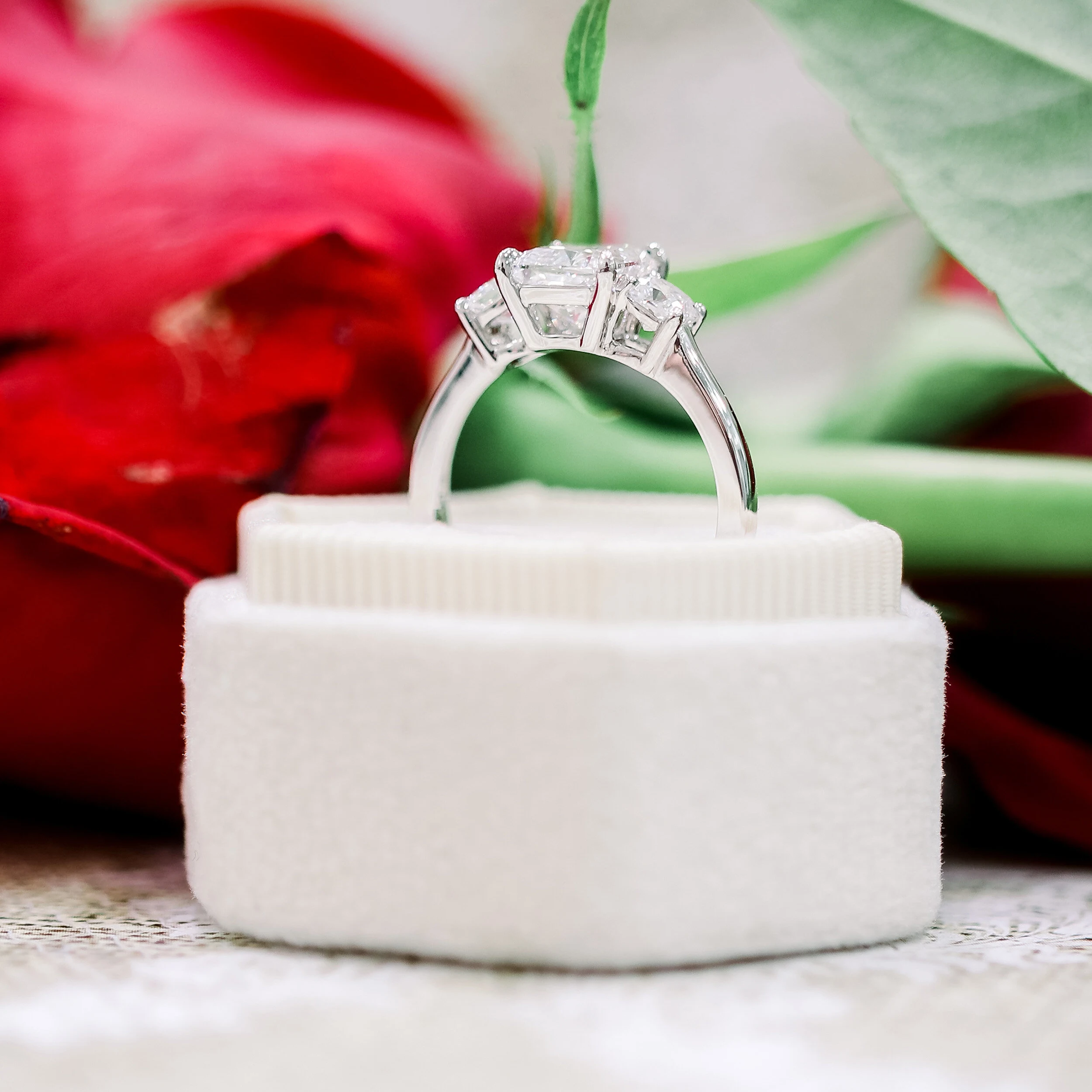cushion three stone engagement ring with 1.5ct lab grown cushion cut diamond center stone and platinum setting