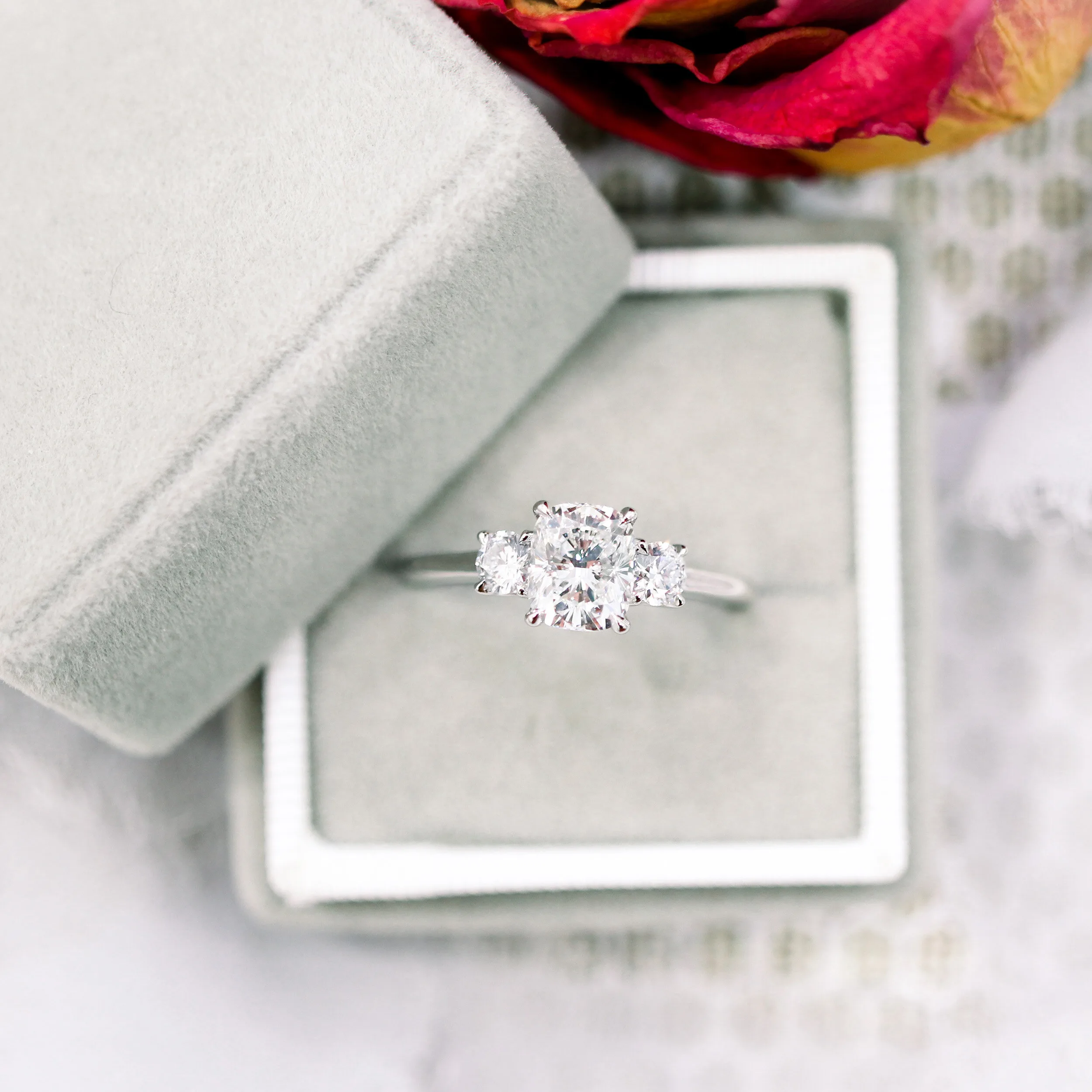 custom three stone ring with lab grown cushion and round side stone diamonds