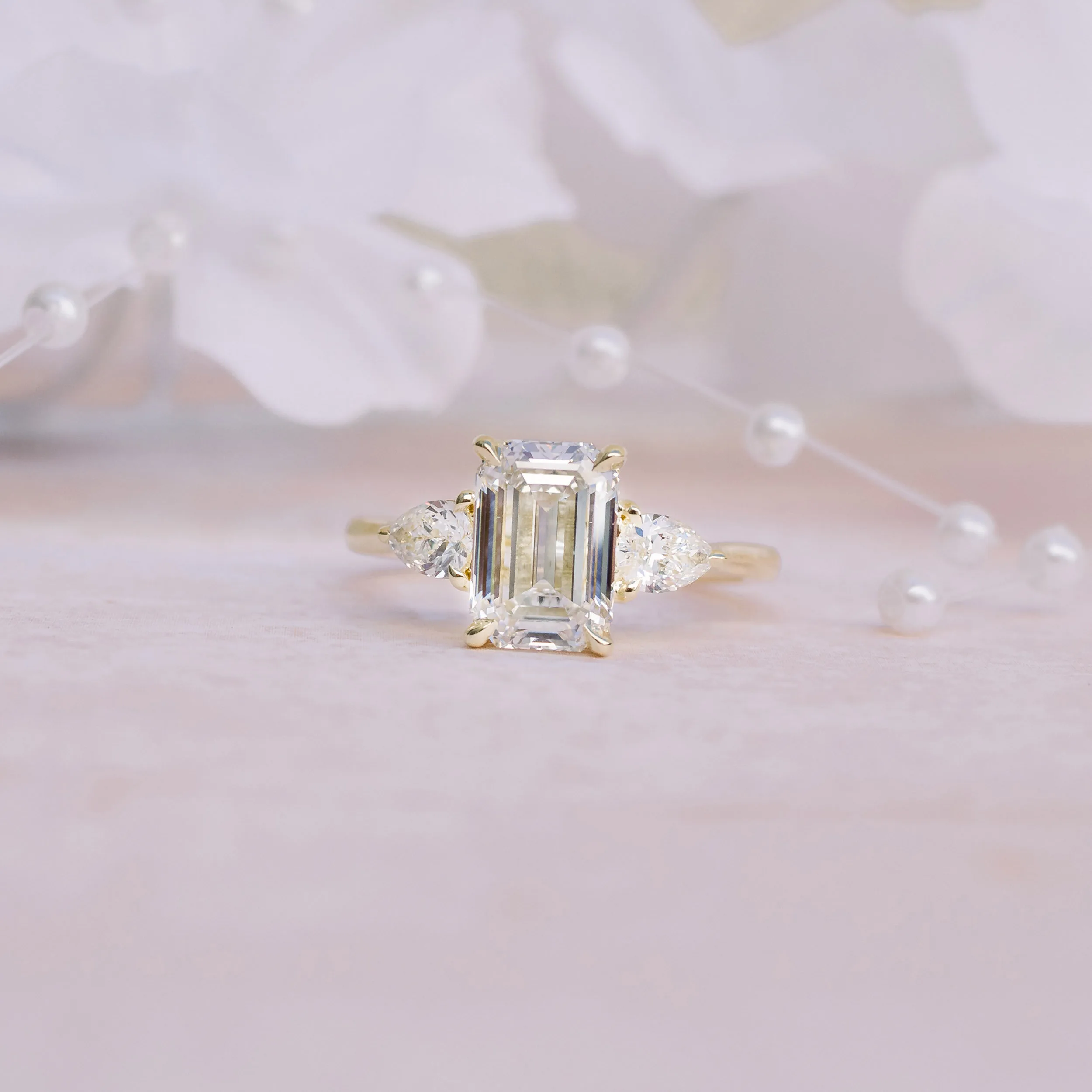 Yellow Gold 2ct Emerald Cut and Pear Three Stone Manmade Diamond Ring Ada Diamonds Design AD-467 Artistic Image