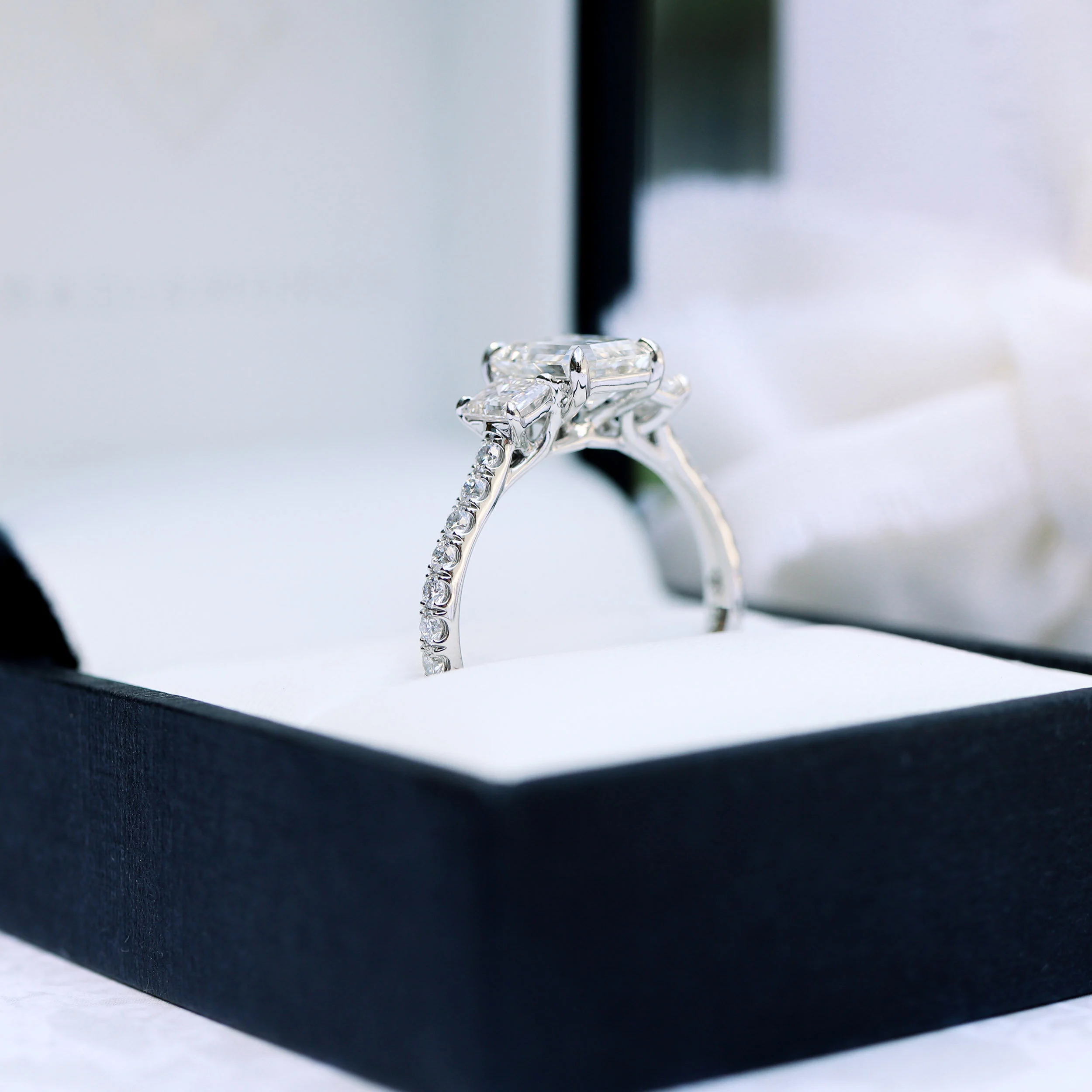 platinum white gold three stone pave ring with lab created emerald cut diamonds