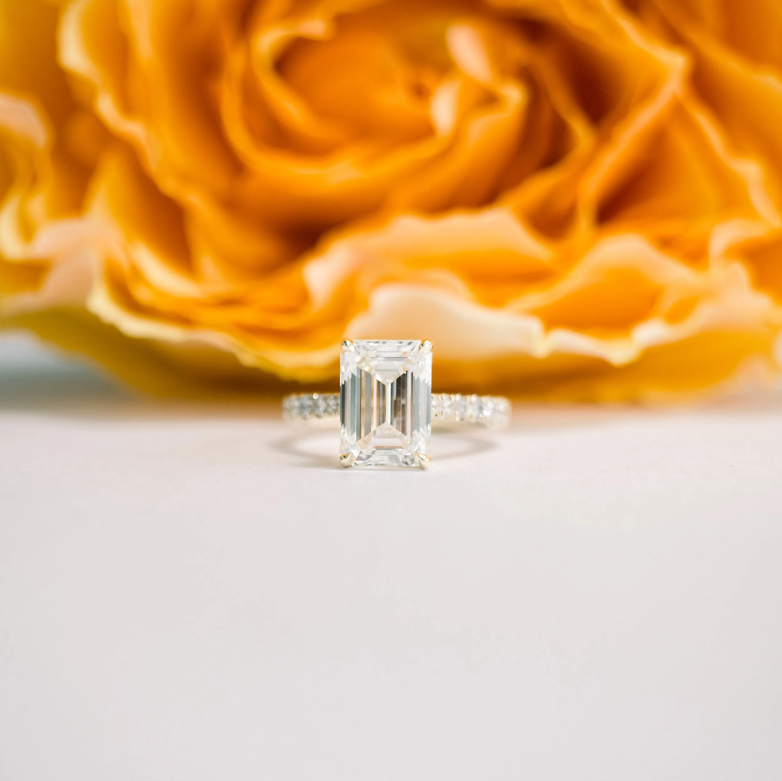 yellow gold four carat emerald cut manmade diamond pavé engagement ring with tapered band ada diamonds design ad 152