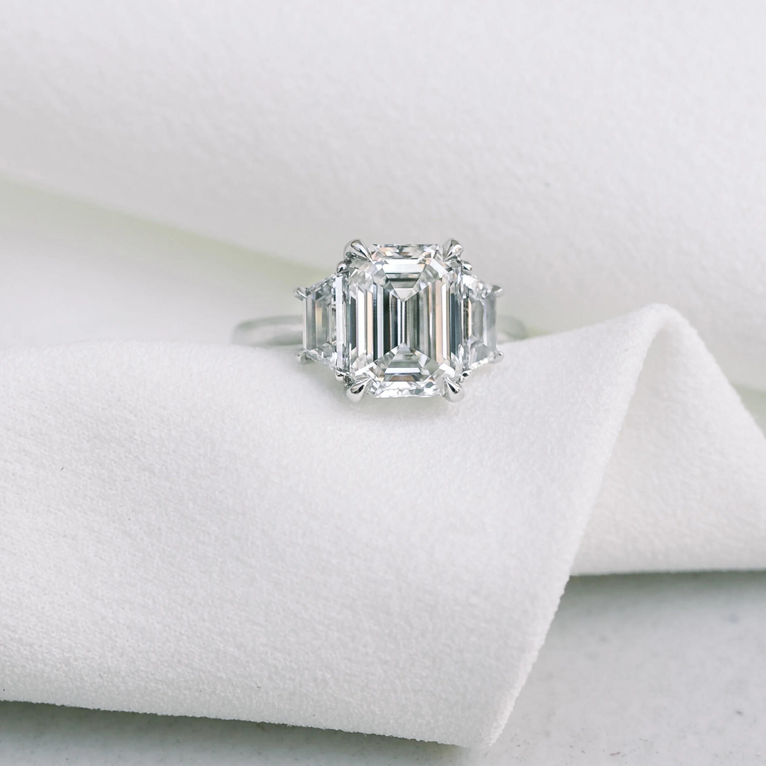 white gold three stone ring with emerald cut and trapezoid lab diamonds