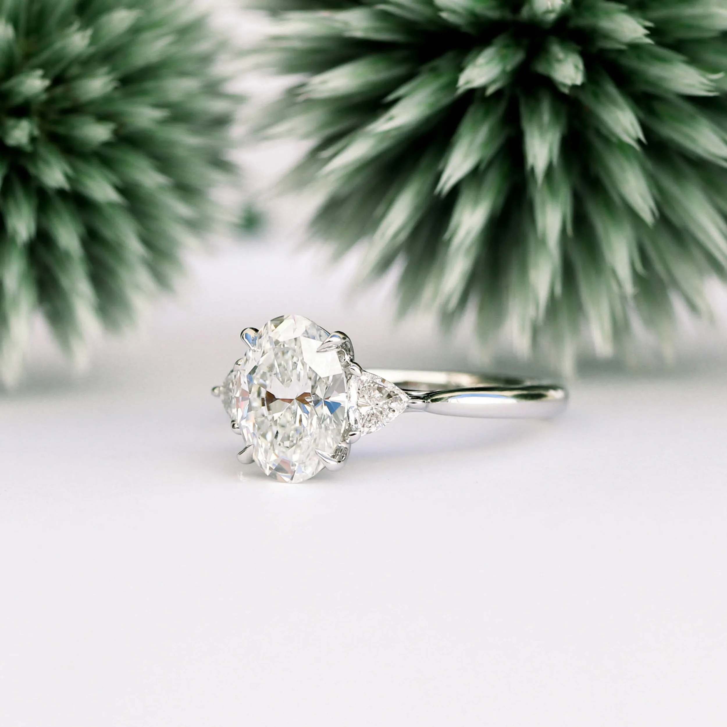 platinum engagement ring featuring 3ct oval lab grown diamond with trillion side stones