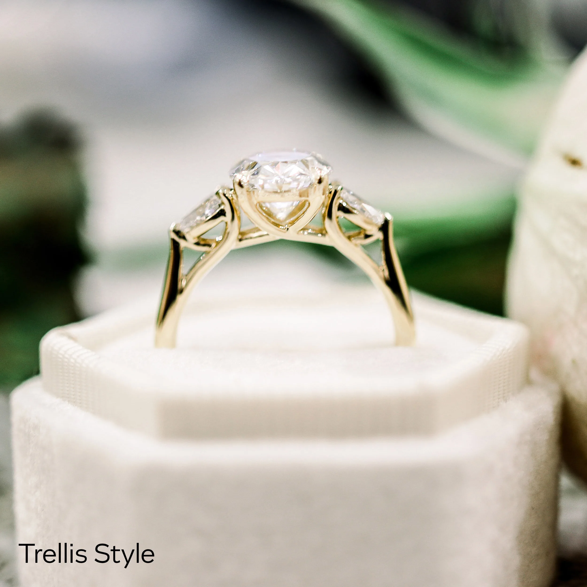 2ct oval lab grown diamond with pear side stones set in 14k yellow gold trellis style engagement ring
