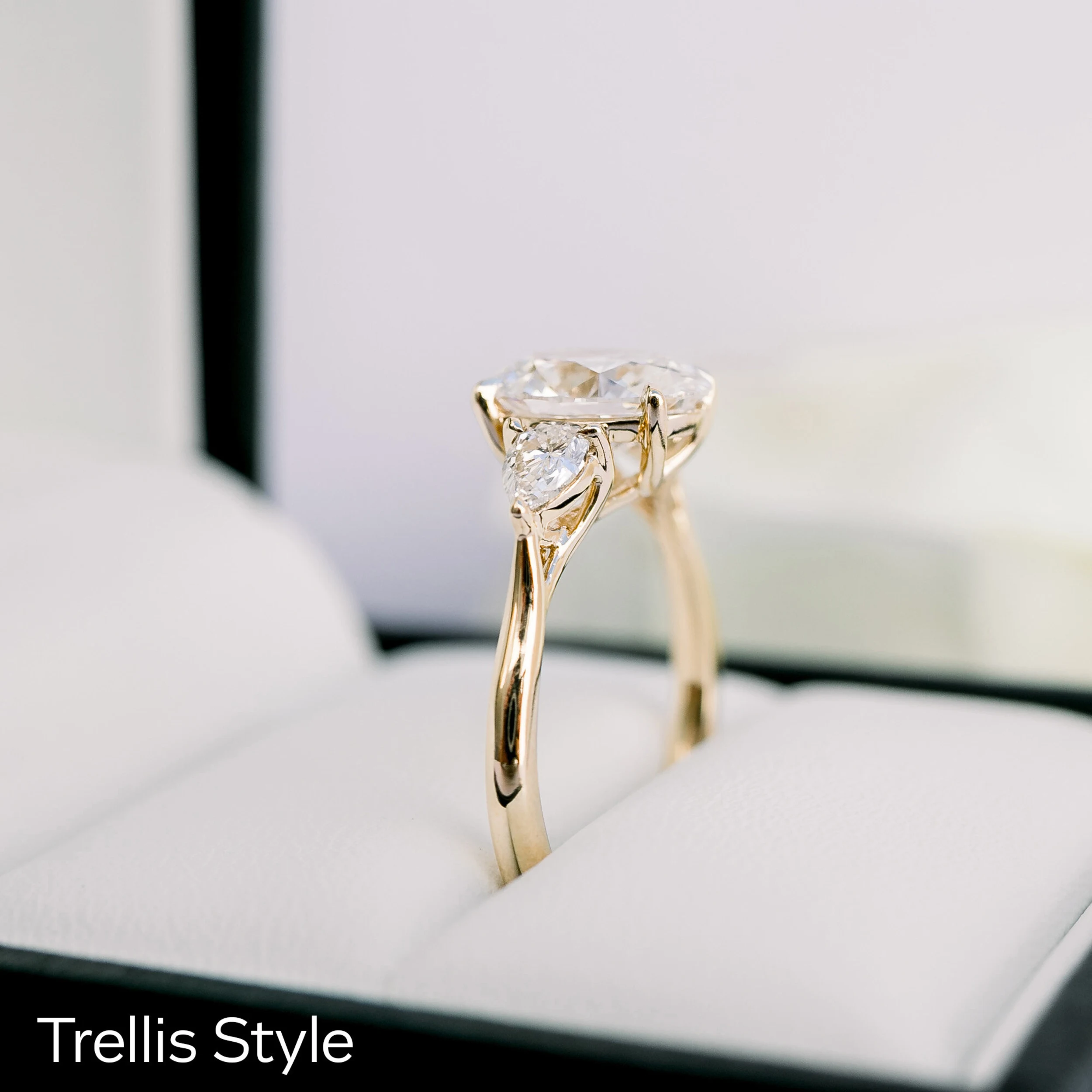 18k yellow gold oval and pear setting with a trellis featuring lab created oval diamond center stone and pear side stones