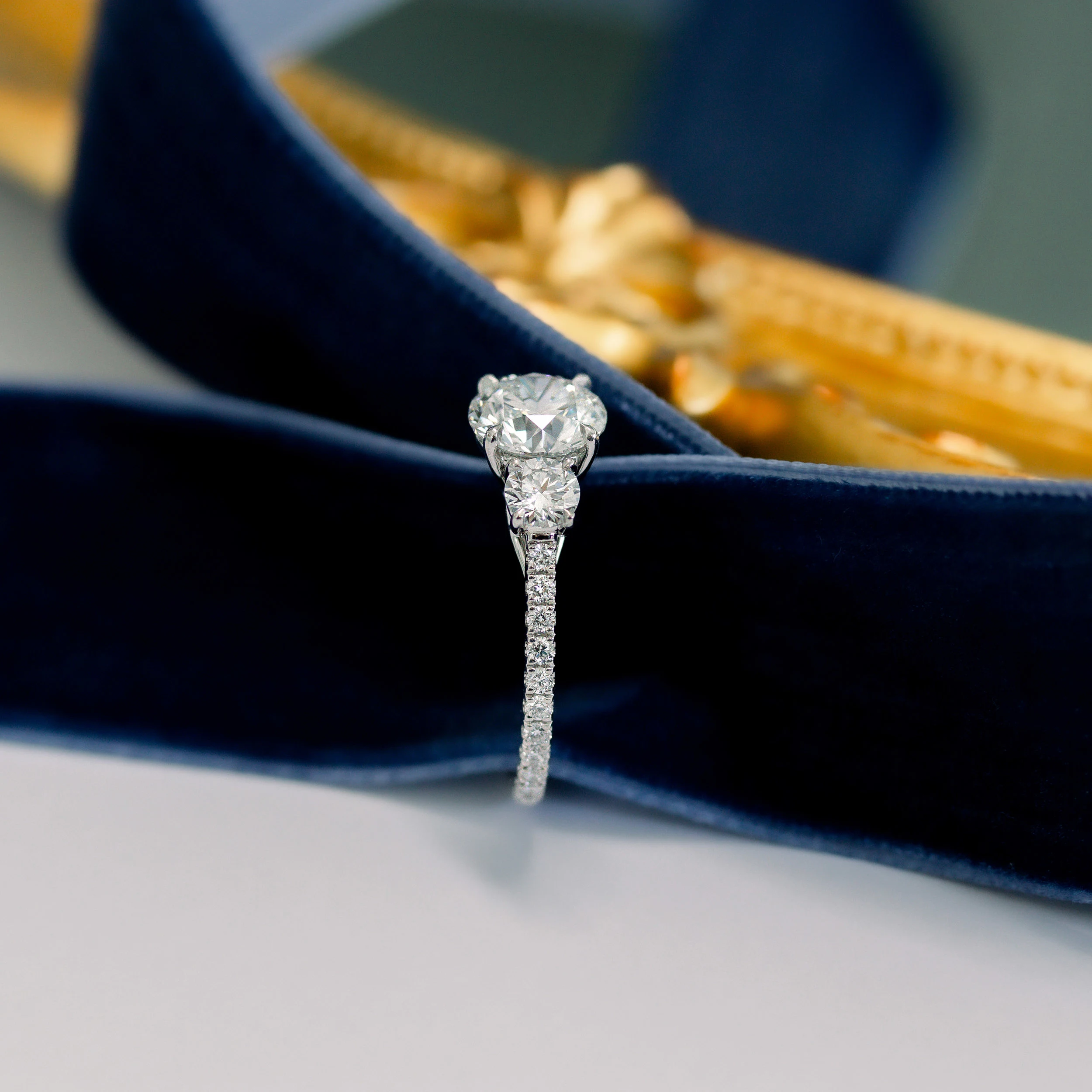 Platinum Round Three Stone Pavé Diamond Engagement Ring featuring 3.0 ctw Diamonds (Side View)