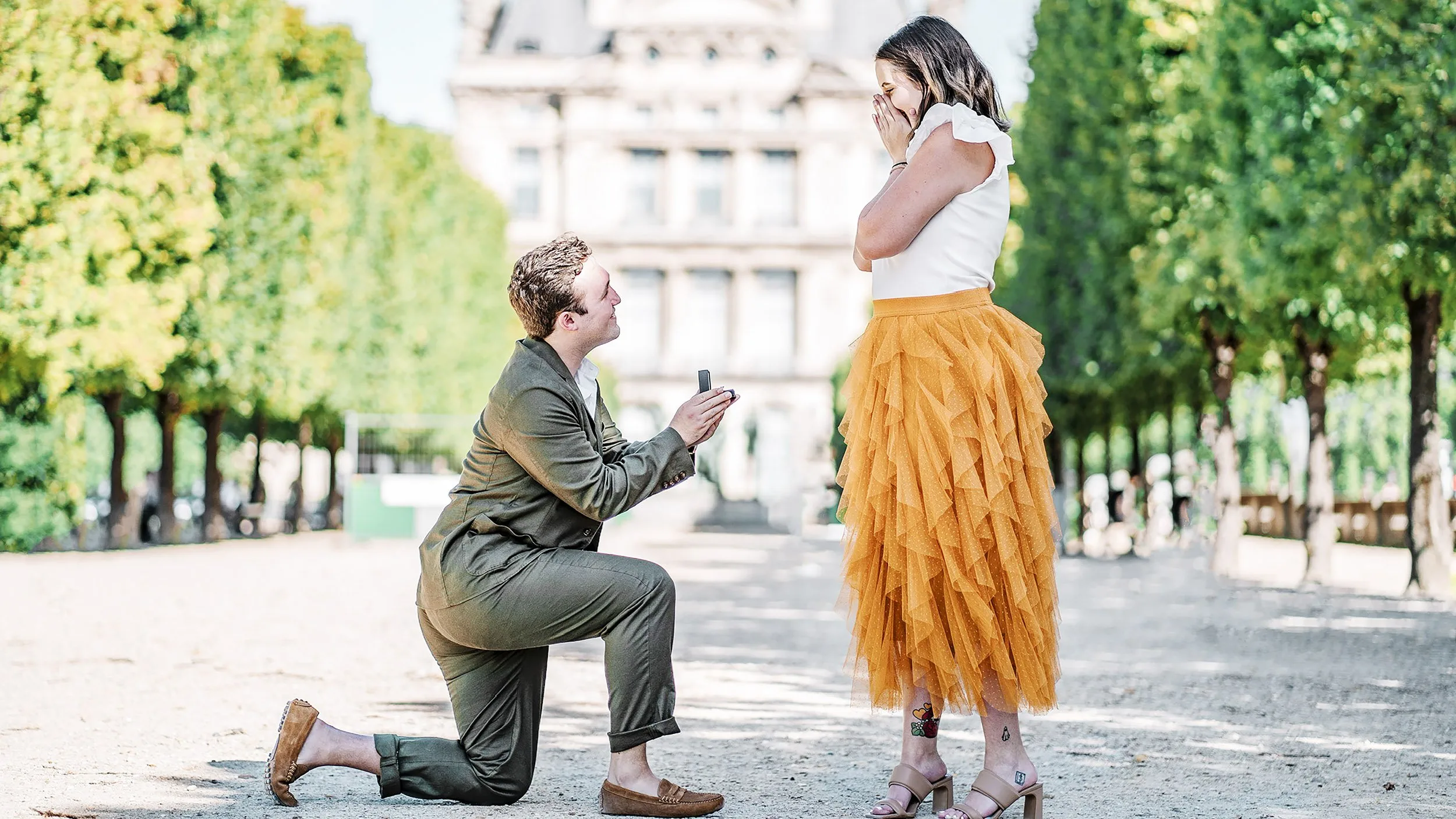 Man on one knee proposing with a lab diamond engagement ring in Paris