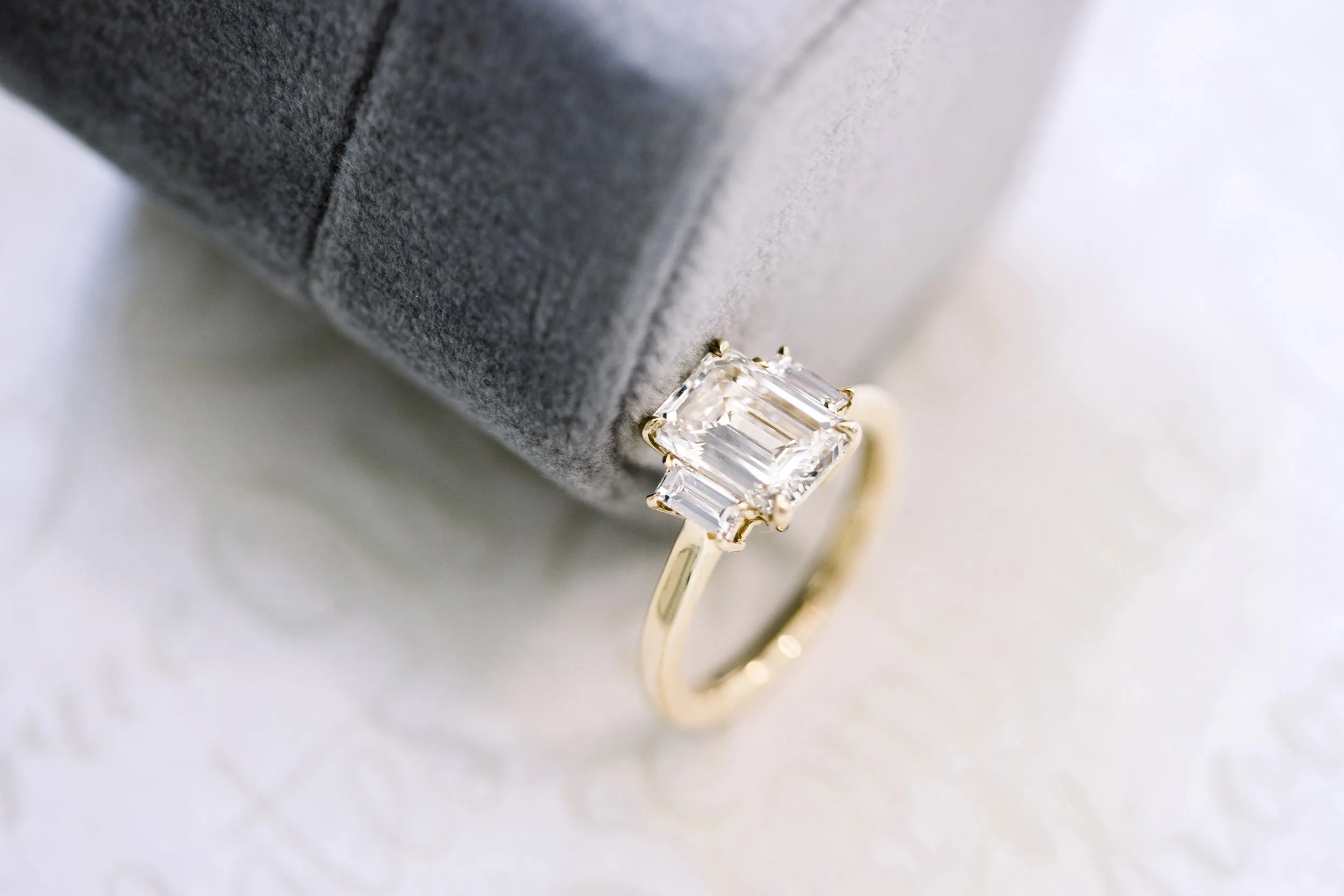 yellow gold three stone ring with lab diamond emerald cut