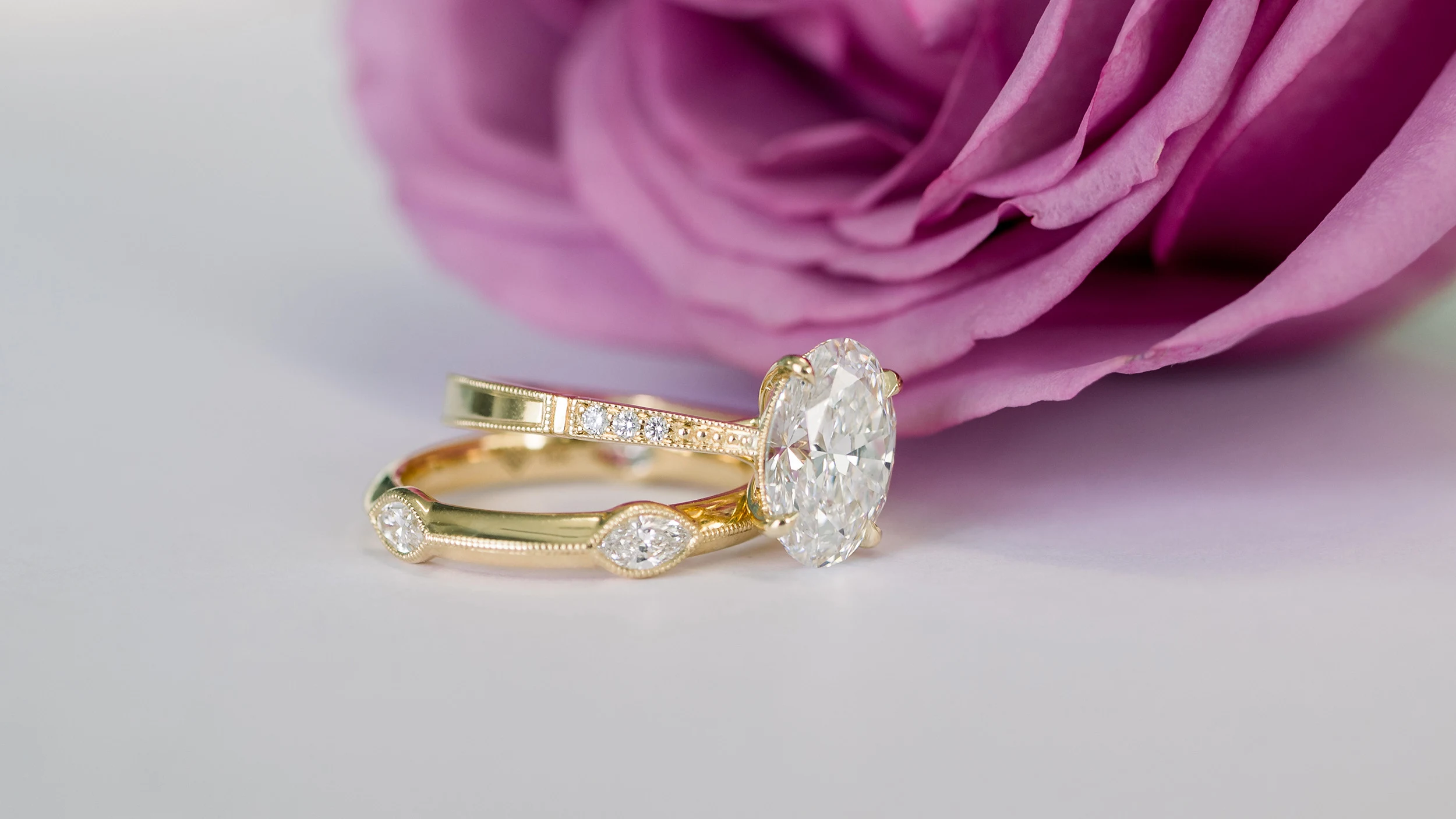 yellow gold wedding set featuring an oval diamond band and marquise wedding band